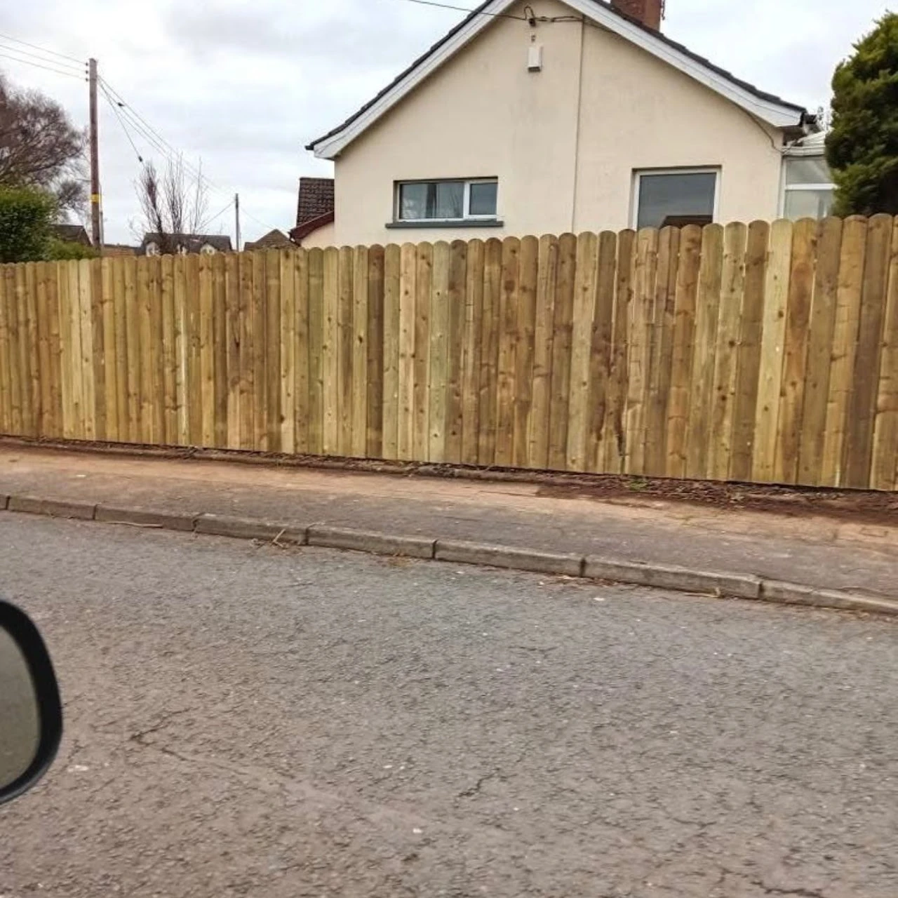 New fence next to a 2 storey house.