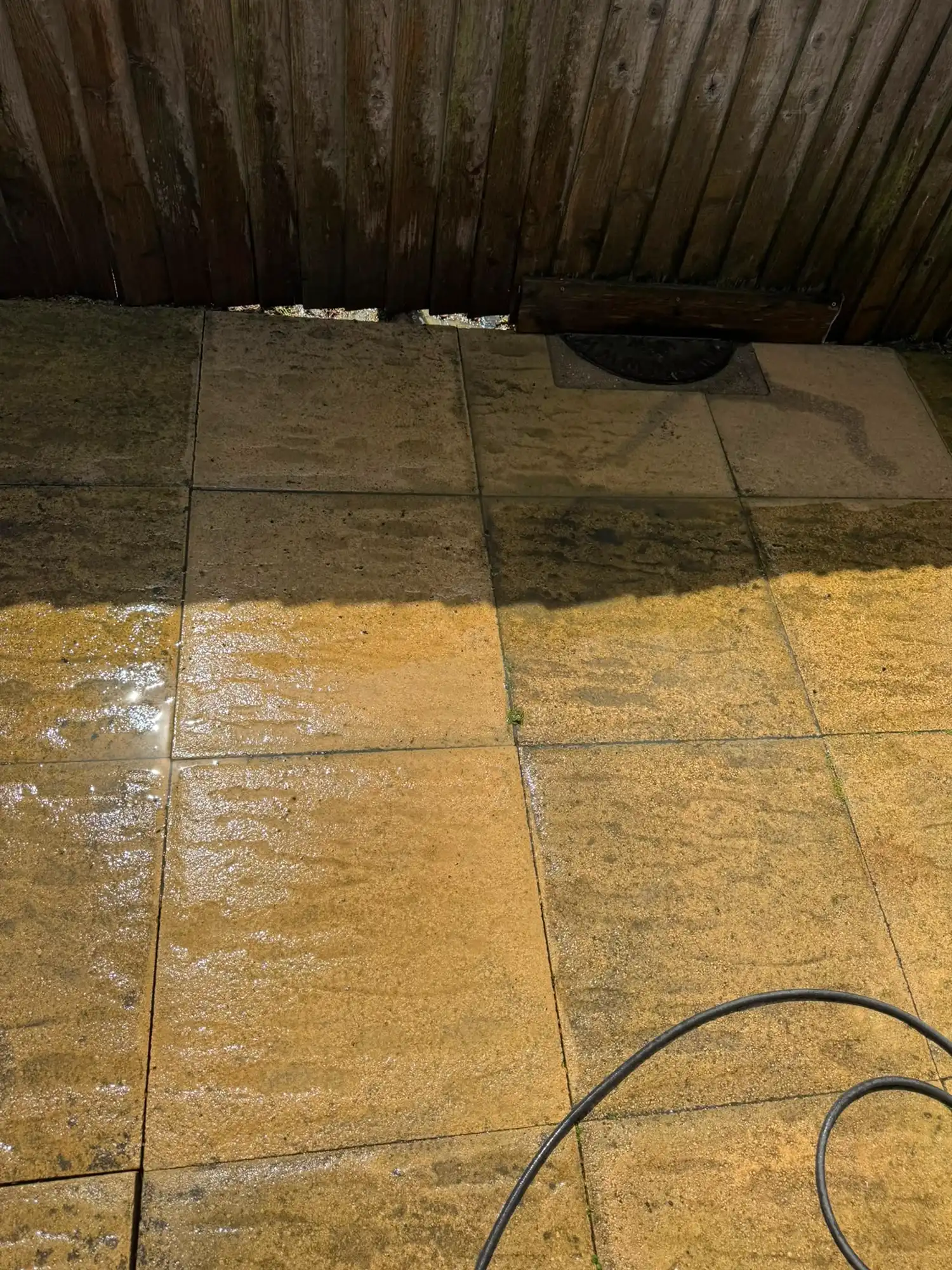 Patio being cleaned with a power washer.