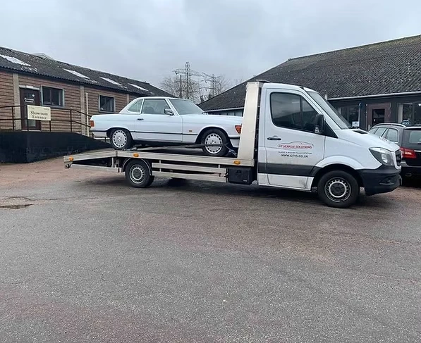 Broken down classic Mercedes on the back of a lorry.
