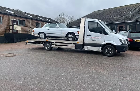 Broken down Mercedes on the back of a pick up lorry.