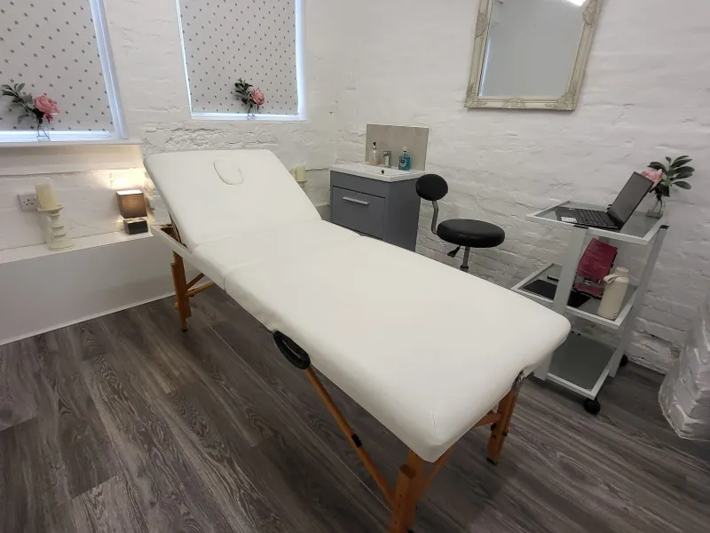 A white massage table in a white room.