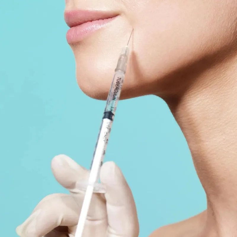A woman with a needle by her mouth.