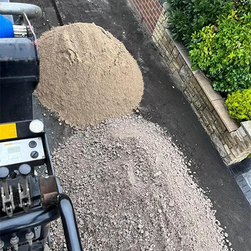A pile of gravel sitting next to a street.