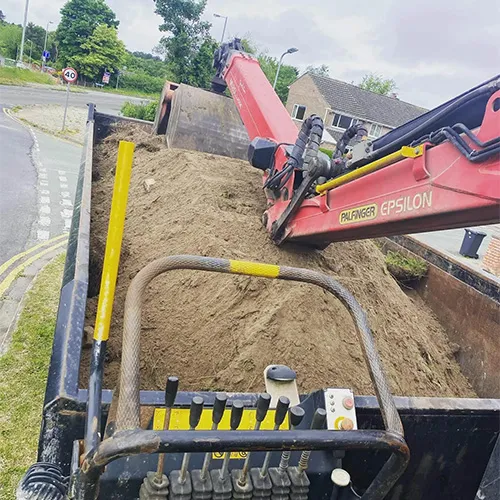 A red bulldozer digging a pile of dirt.
