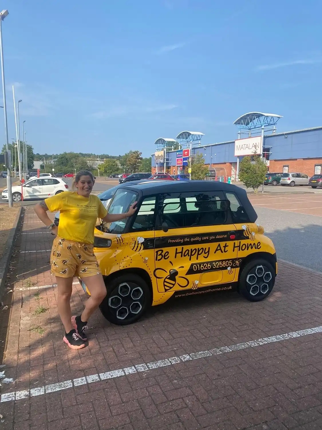 yellow car with lady standing in front of it