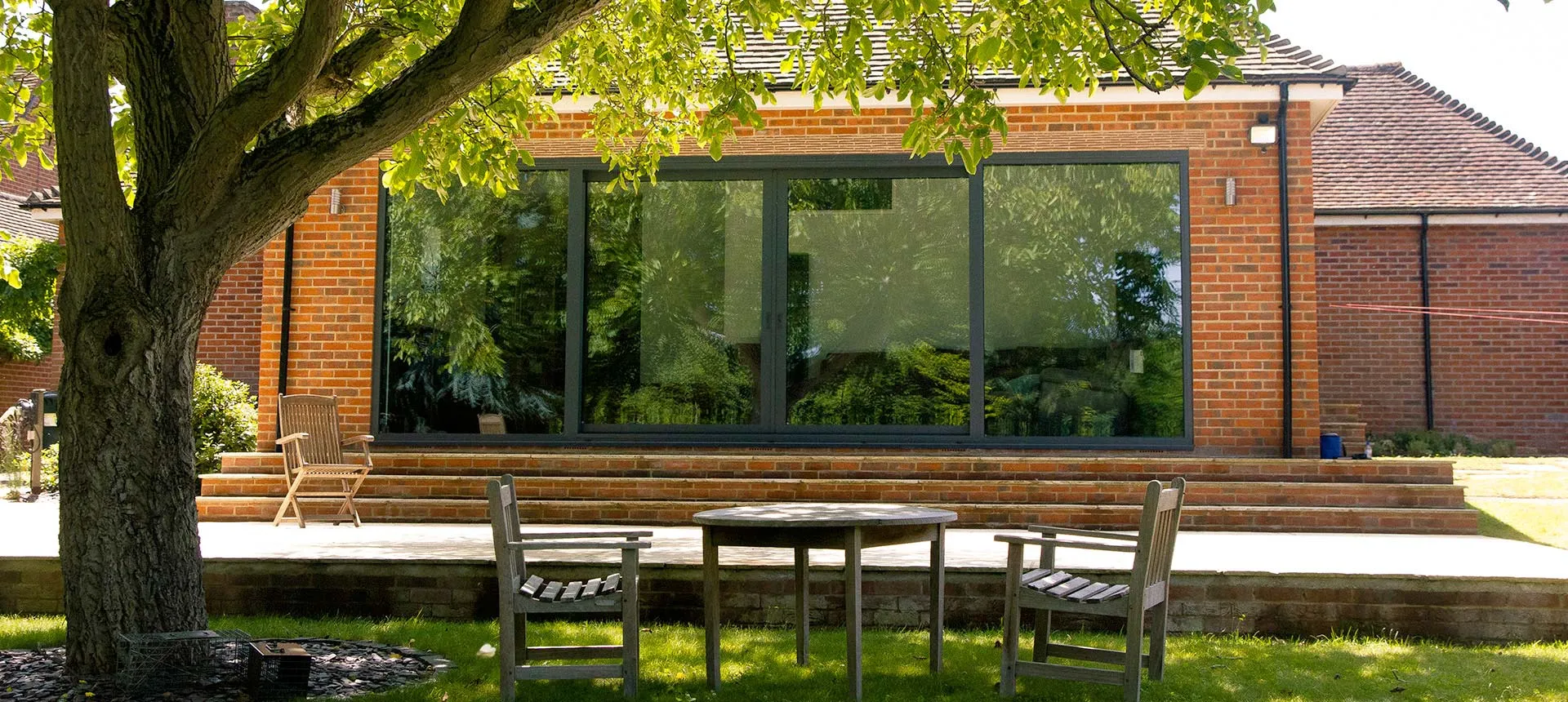 a patio with a table and chairs under a tree