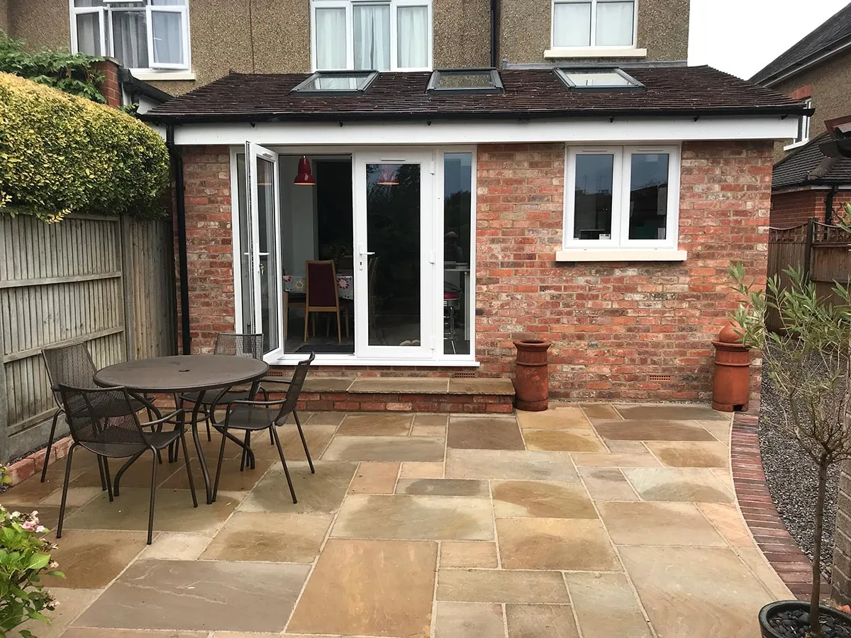 a patio with a table and chairs next to a brick building