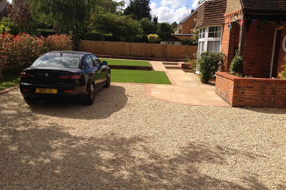 a black car parked in a driveway next to a house