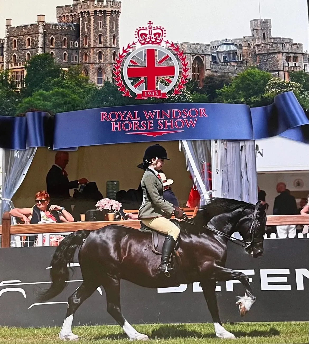 A person riding a horse in front of a crowd.