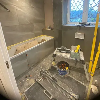 A bathroom being remodeled with a tub and tools.