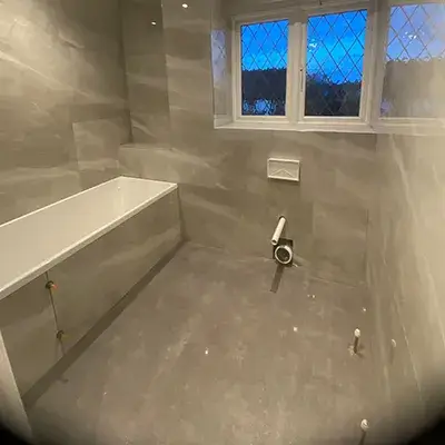 A bathroom with a toilet and a window.