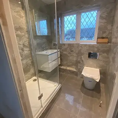 A bathroom with a walk in shower next to a toilet.