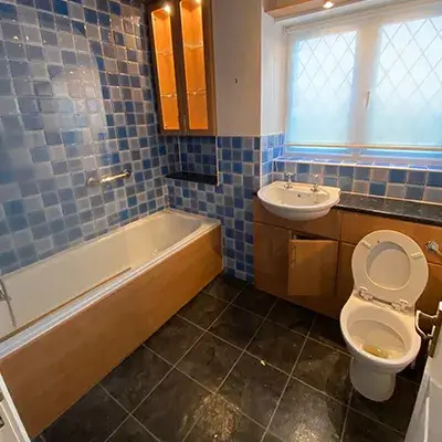 A bathroom with a tub, toilet and sink.