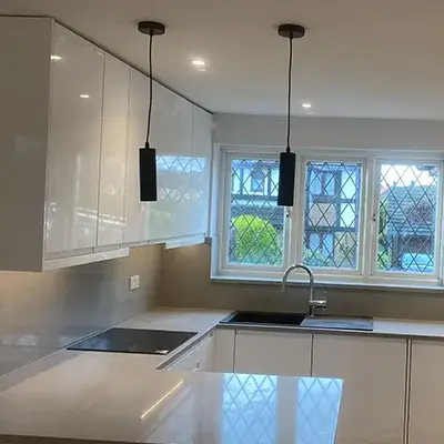 A kitchen with white cabinets and a window.