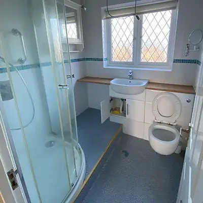 A bathroom with a toilet, sink, and shower.