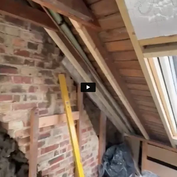A room with a brick wall and a ladder.