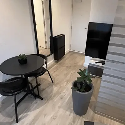 A room with a table, chairs and a television.