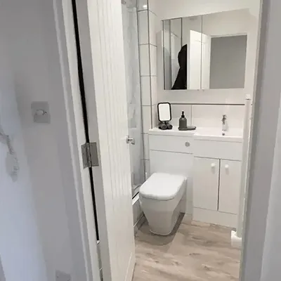 A bathroom with a toilet, sink, and mirror.