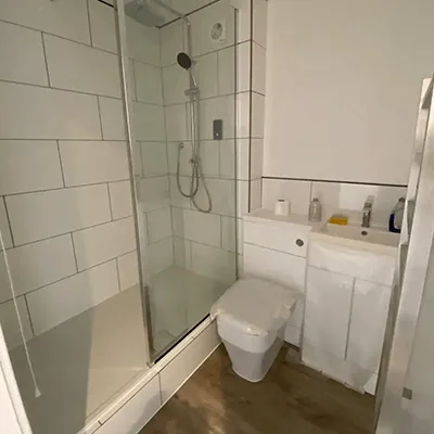 A bathroom with a shower, toilet and sink.