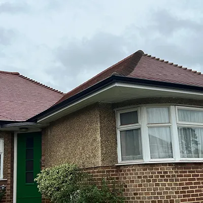A brick house with a green door and window.