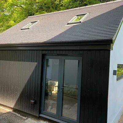 A small house with a black roof and windows.
