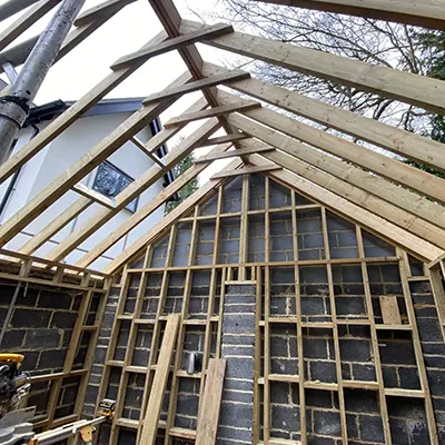 A house being built with a roof made of wood.