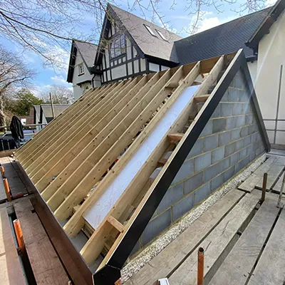 A house being built with a roof being installed.