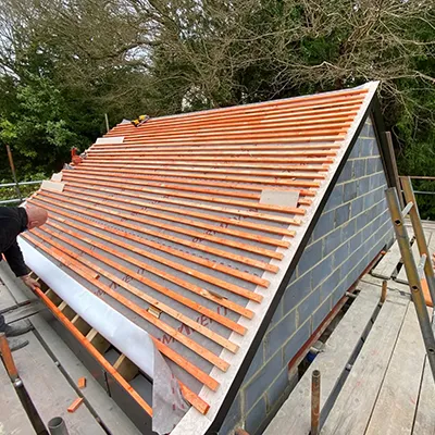 A man working on a metal roof on a house.