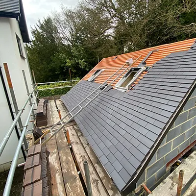 A house being built with a metal roof.