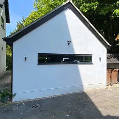 A white house with a car in the window.