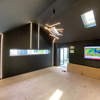 An empty room with a television and a large window.