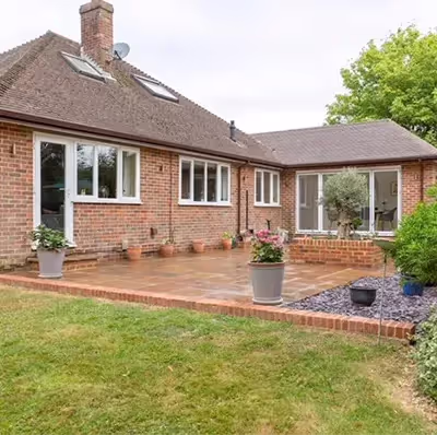 A brick house with a patio and a large garden.