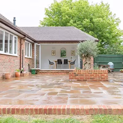 A backyard with a patio and brick steps.