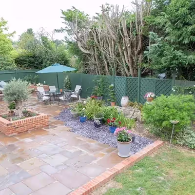 A patio with a table and chairs next to a fence.