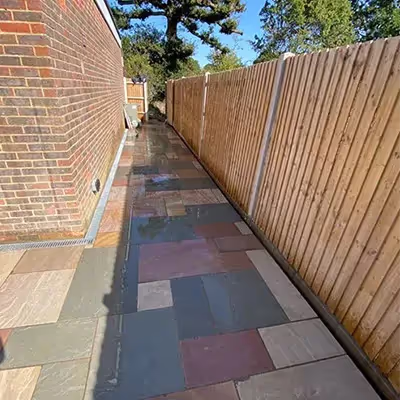 A wooden fence next to a brick wall.
