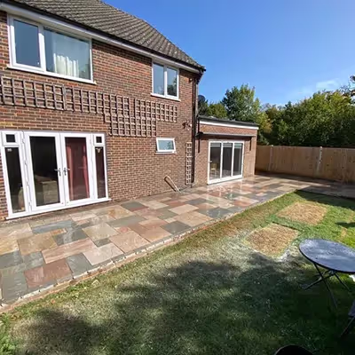 A patio with a table and chairs next to a brick building.