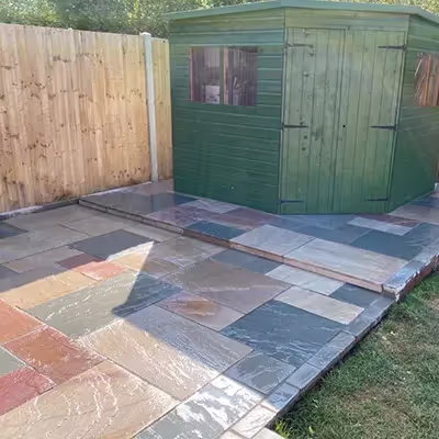 A small shed sitting next to a wooden fence.