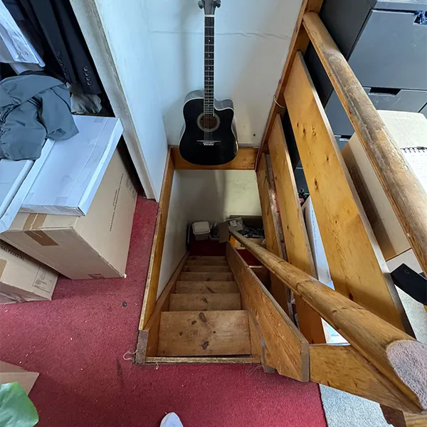 A guitar sitting on top of a wooden stair case.