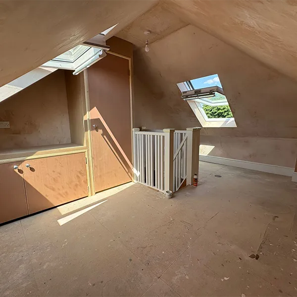 An empty room with a ladder and a window.