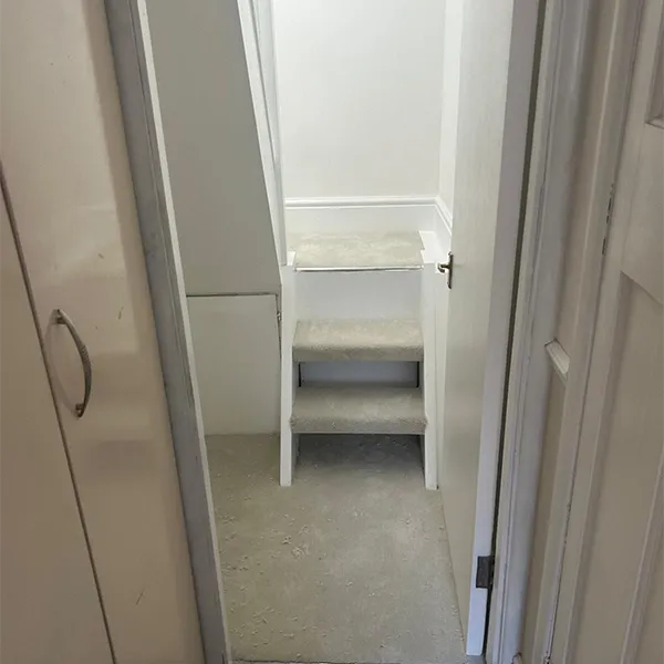 A narrow hallway leading to a white closet.