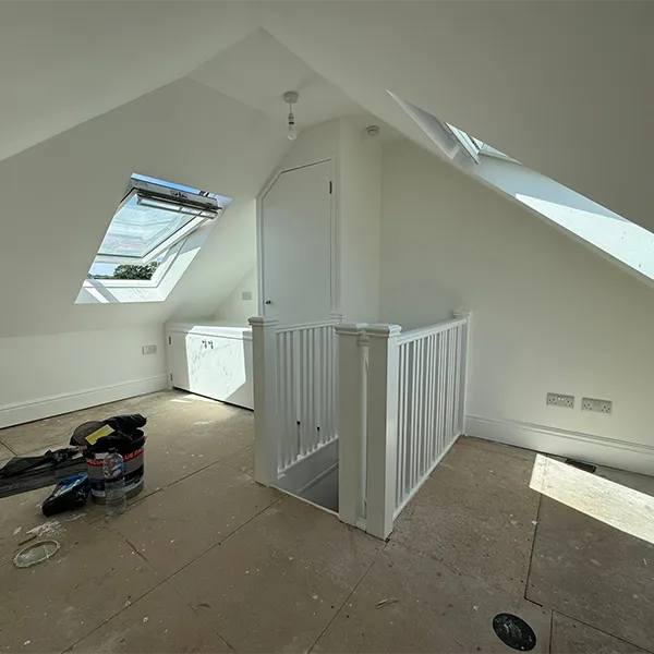 A room with a skylight and some tools on the floor.
