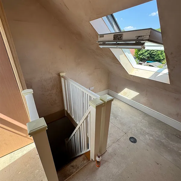 A room with a skylight and a stair case.