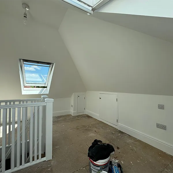A room with a skylight and a white railing.