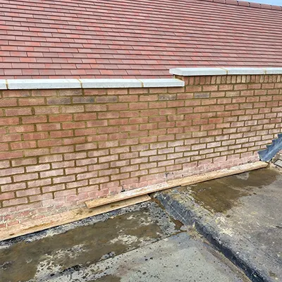 A fire hydrant sitting on the side of a brick building.
