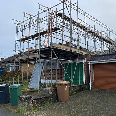 A house under construction with scaffolding on the roof.