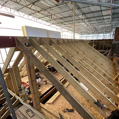 A group of people working on a wooden structure.