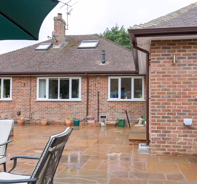 A patio with a table and chairs and an umbrella.