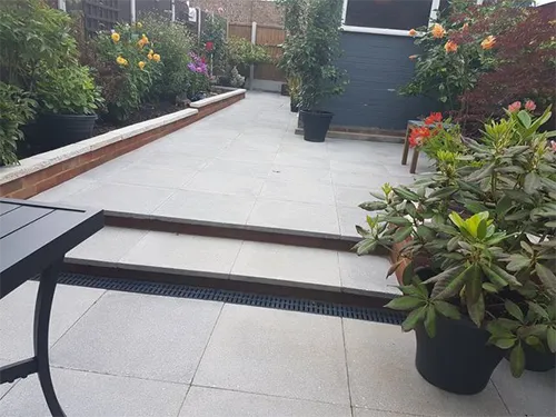 a patio with a table and some plants