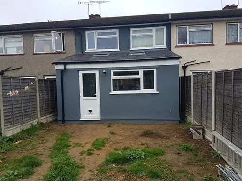 a grey house with a white door and windows