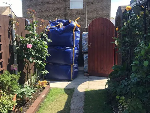 a large bag of blue bags sitting in the middle of a yard